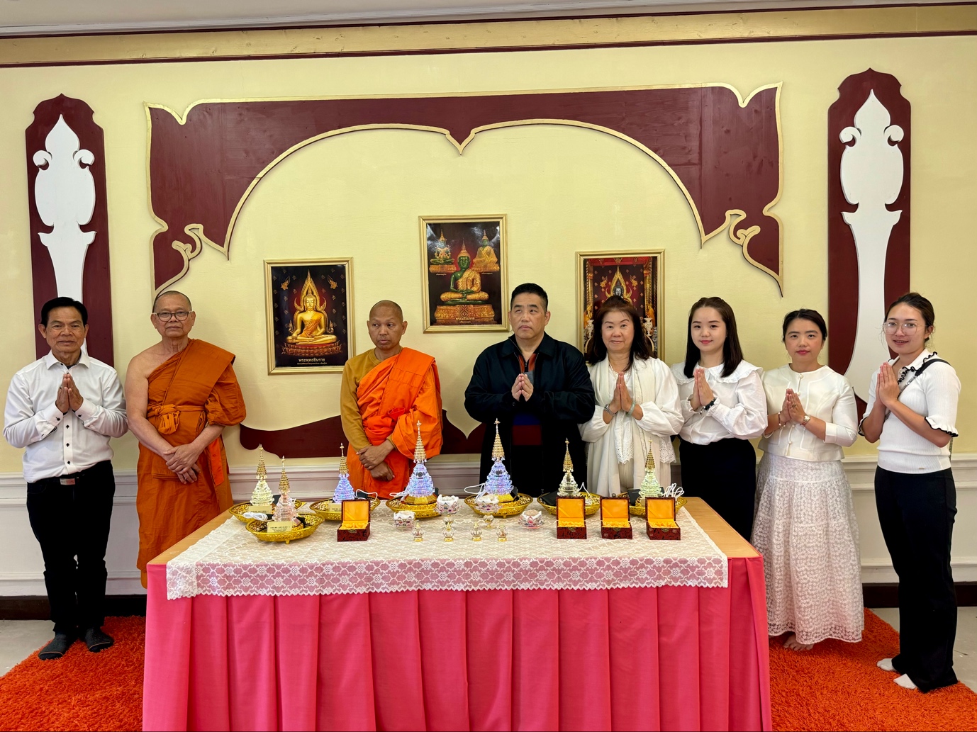 A group of people standing around a table
Description automatically generated